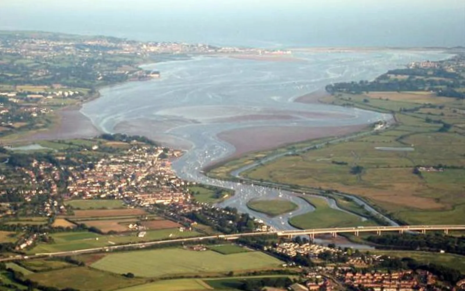 Aerial view of an estuary with river channels meeting tidal waters